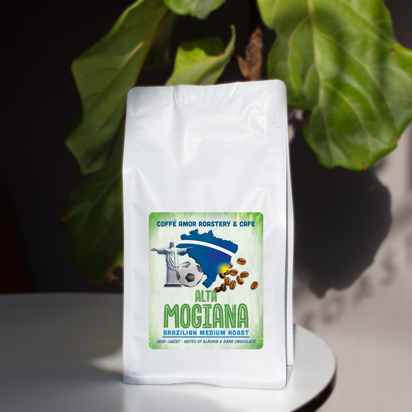 White coffee bag with a Brazil Alta Mogiana coffee label against a green leafy background