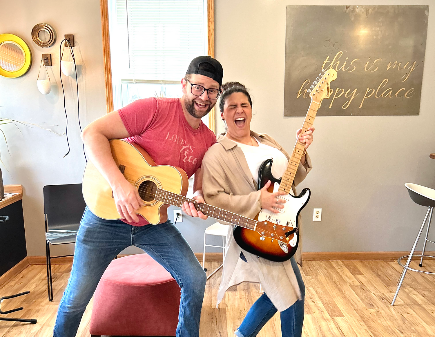 two people playing guitars in a cafe